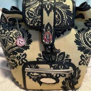Spartina 449 backpack with magnetic closure and buckle closure, and drawstring.